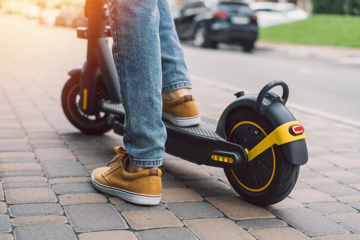 Mann fährt E-Scooter auf der Straße – E-Scooter Reparatur Oberberg